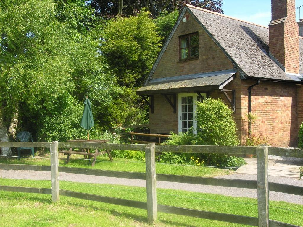 an old house with a fence and an umbrella at Annexe- Ukc4917 in Timberscombe