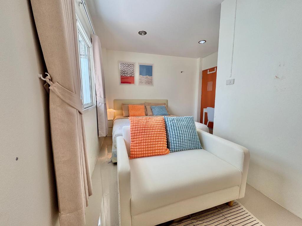 a small bedroom with a bed and a chair at Boon Poshtel Hatyai in Sathani Hat Yai