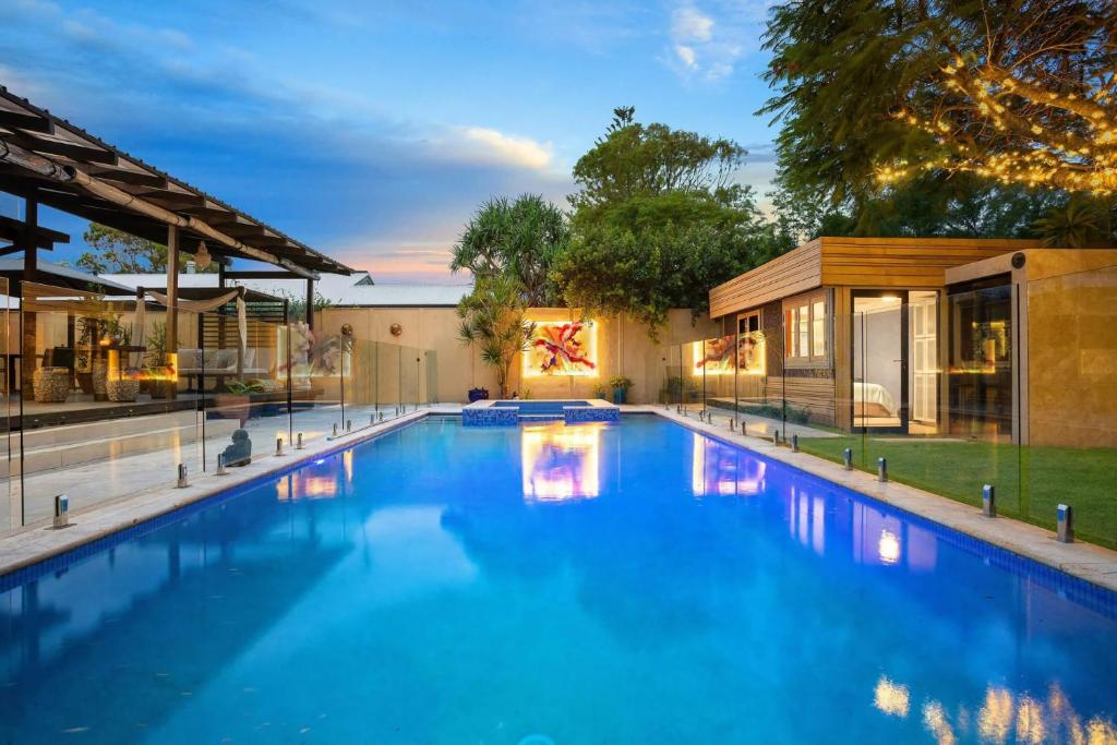 a large blue swimming pool with a house at Mokum House Designer Escape with Pool Sauna in Brisbane