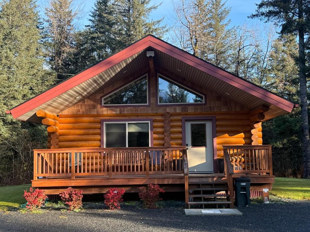 a log cabin with a large front porch and a front porch at Clear Creek Cabins in Seward