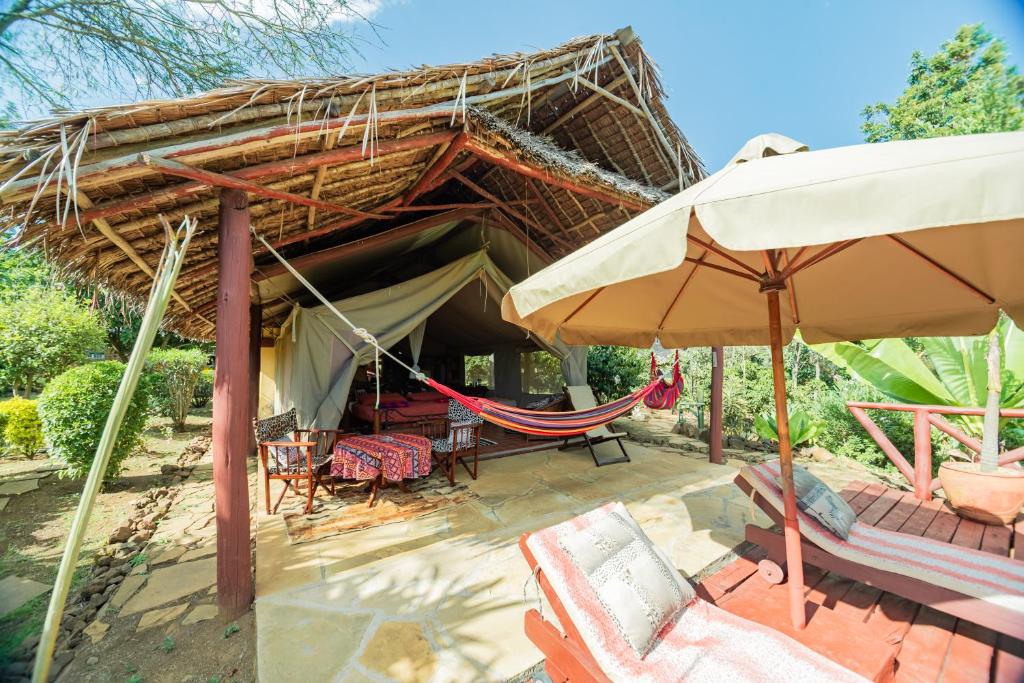 a resort with a hammock and a tent at Buffalo's Rest Greenpark-Naivasha in Naivasha