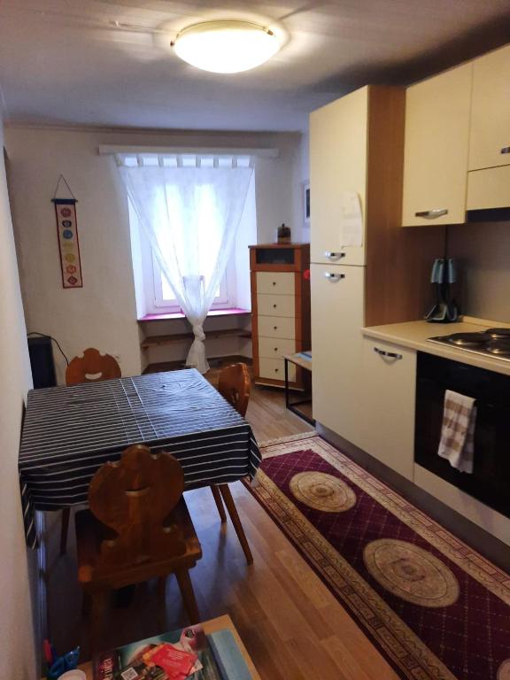 eine Küche mit einem Tisch und eine Küche mit einem Fenster in der Unterkunft Namastè Ca Biasca in Biasca