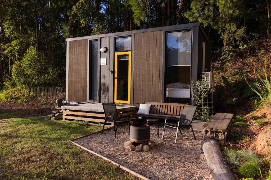a tiny house with a bench and a table at Saddle House by Tiny Away in Lower Beechmont