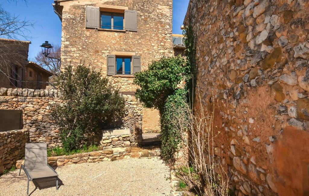 a stone building with a chair in front of it at Maison En Pierres in Rustrel