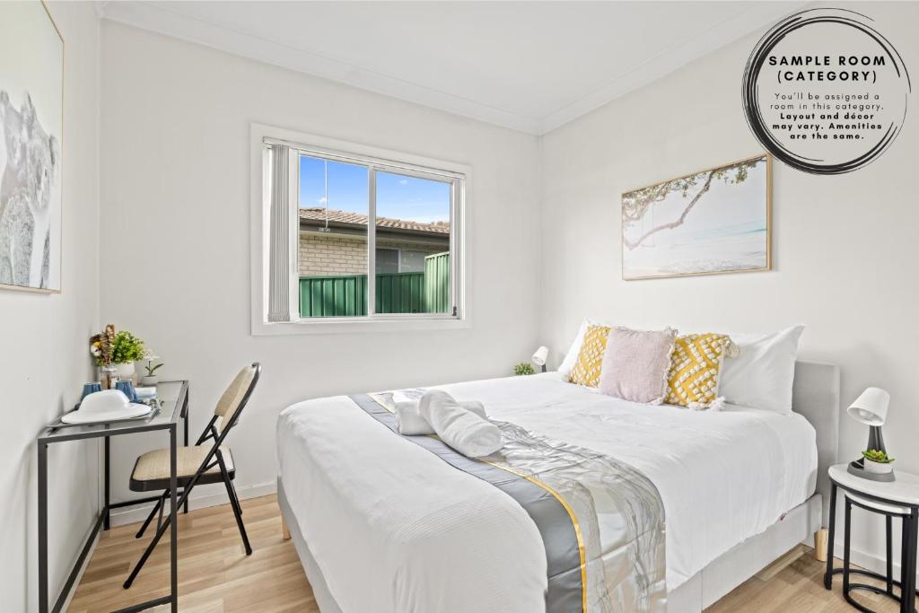 a white bedroom with a bed and a desk at Double Room - Quaint Spot in Marayong - Centrally Located - Shared Bathroom in Blacktown