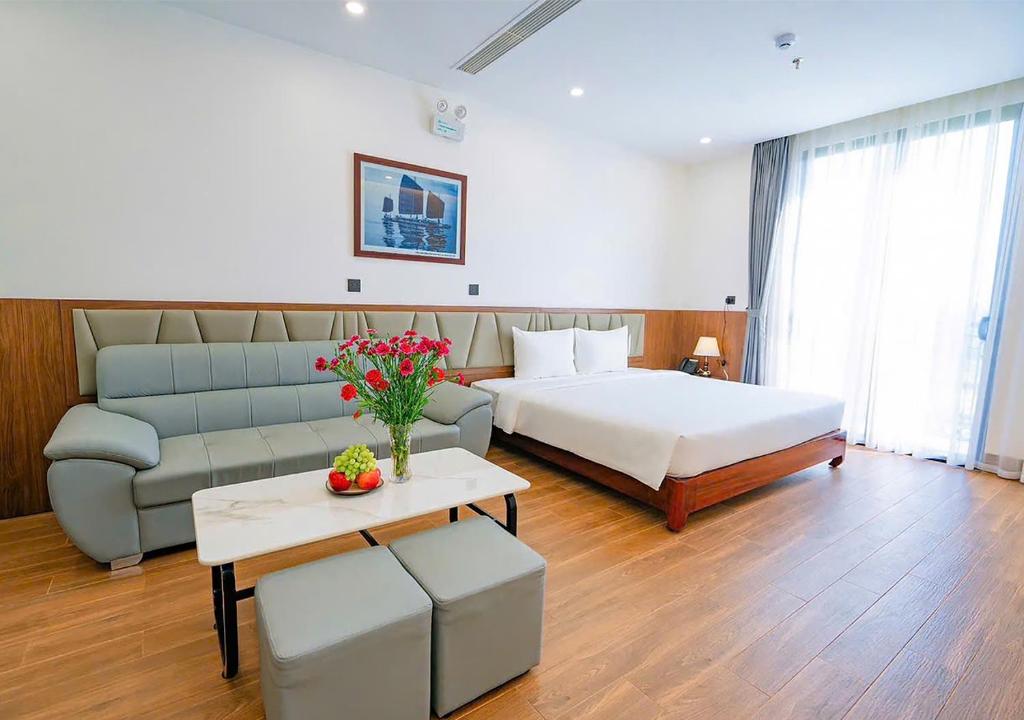 a hotel room with a bed and a couch at Intechco Hotel S1-25 sầm Sơn in Sầm Sơn