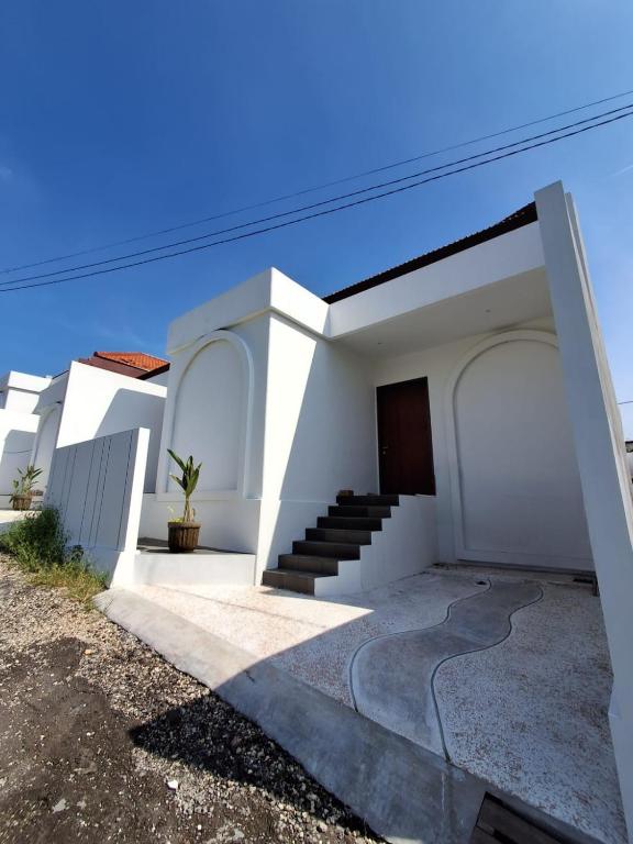 a white house with a door and stairs at Villa Luck Canggu Bali unit 7 in Canggu
