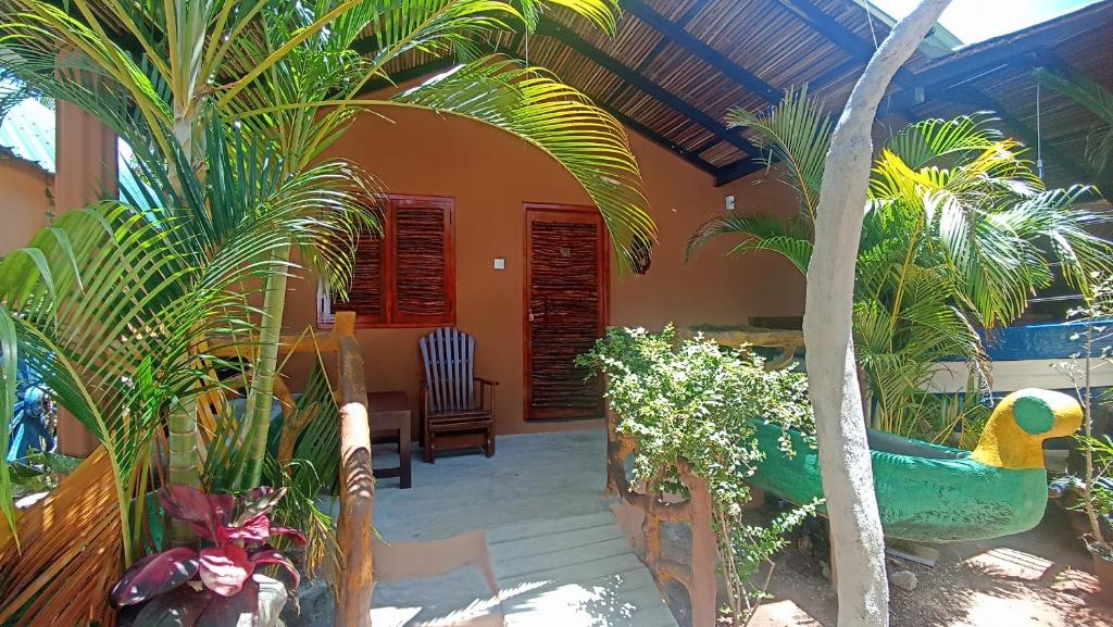 a house with a garden with a peacock in the yard at Nature Beach Huts in Trincomalee