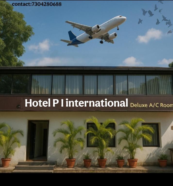 an airplane is flying over a building with palm trees at Hotel P I international in Mumbai