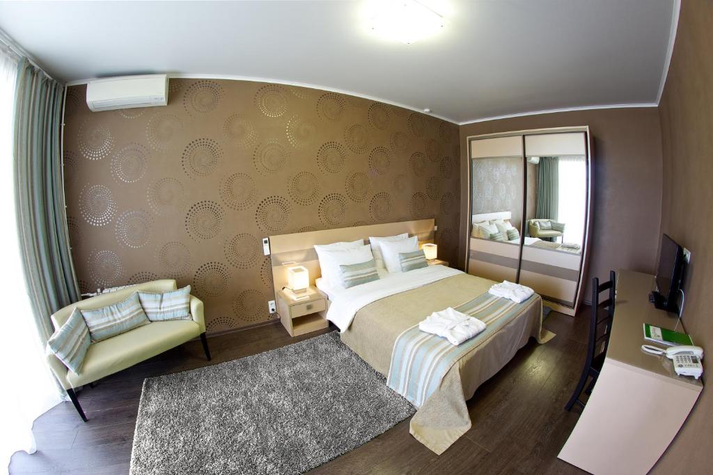 a bedroom with a large bed and a mirror at Green Park Kaluga Hotel in Kaluga