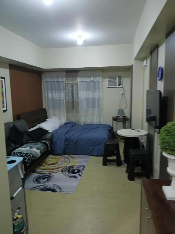 a small room with a bed and a table at Josephine's place at Avida Aspira Tower 2 CDO in Cagayan de Oro