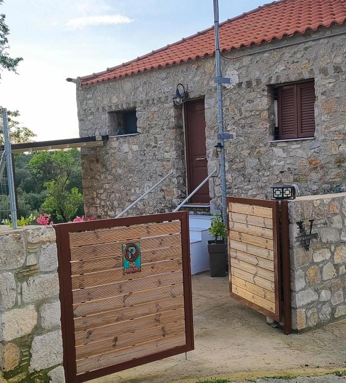 a wooden gate in front of a stone house at Vaki's country house in Pylos