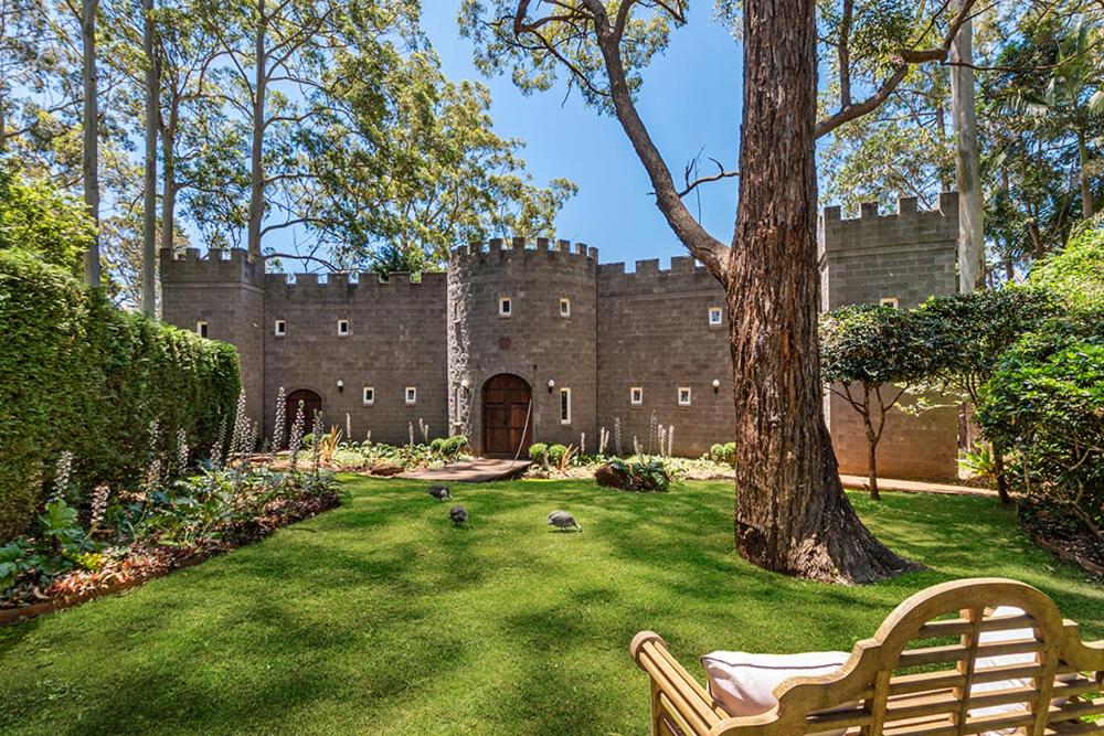 a castle sitting in the middle of a yard with a bench at The Castle on Tamborine in Mount Tamborine