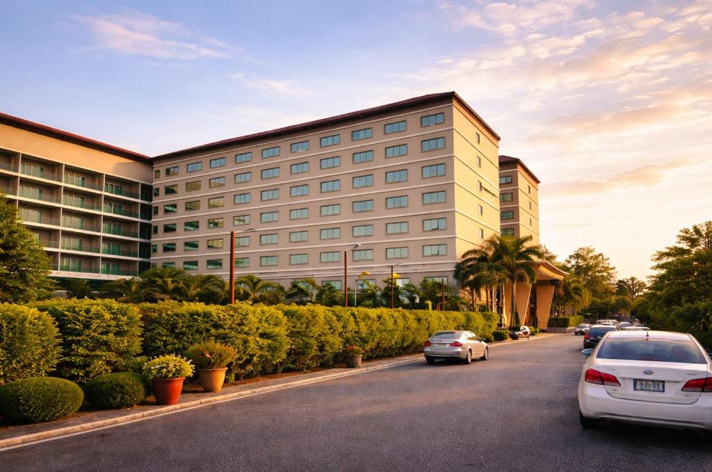 a building with cars parked on the side of a street at Ease Jomtien by Clubhouse in Jomtien Beach