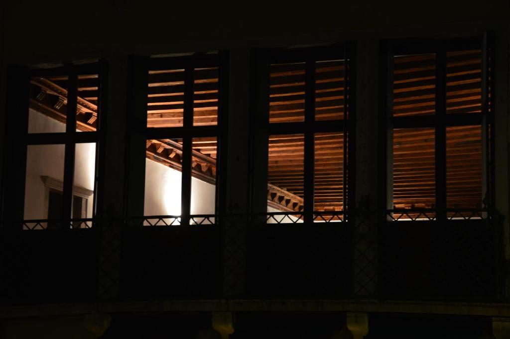 two windows in a building at night at Dorso Duro Apartment in Venice