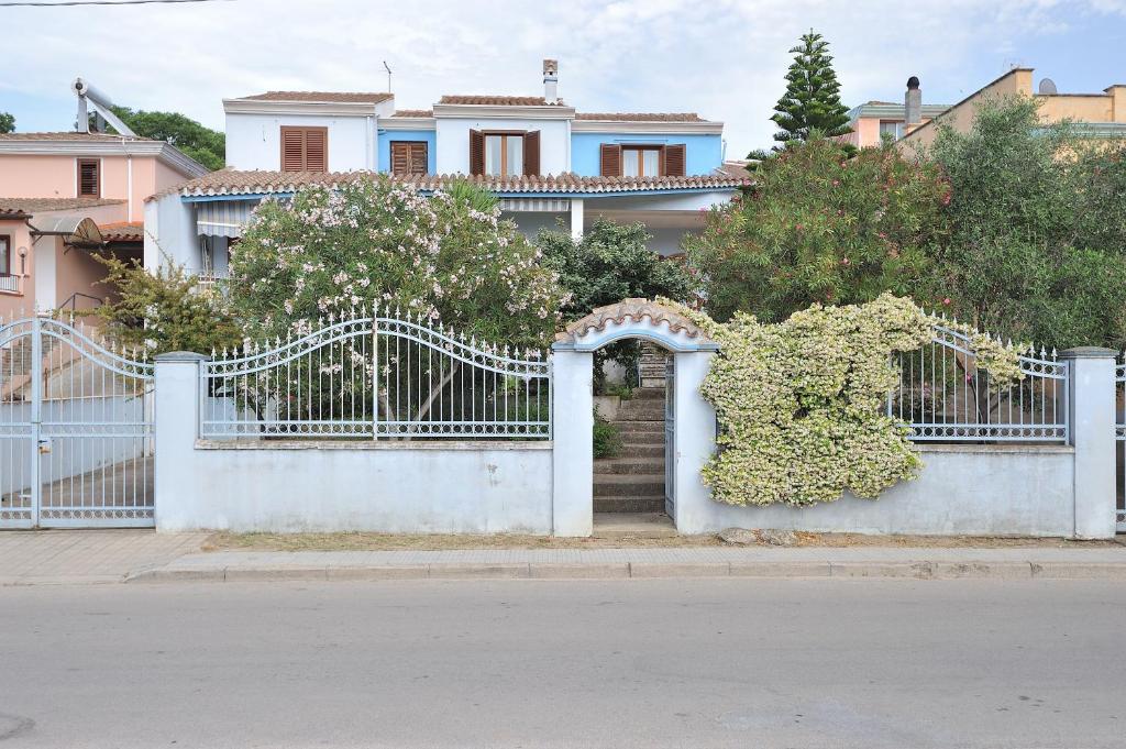 una recinzione bianca con un cancello con dei fiori di The Dream House in Sardinia a Bari Sardo