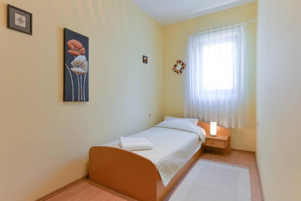 mała sypialnia z łóżkiem i oknem w obiekcie Apartments Doda w mieście Zadar
