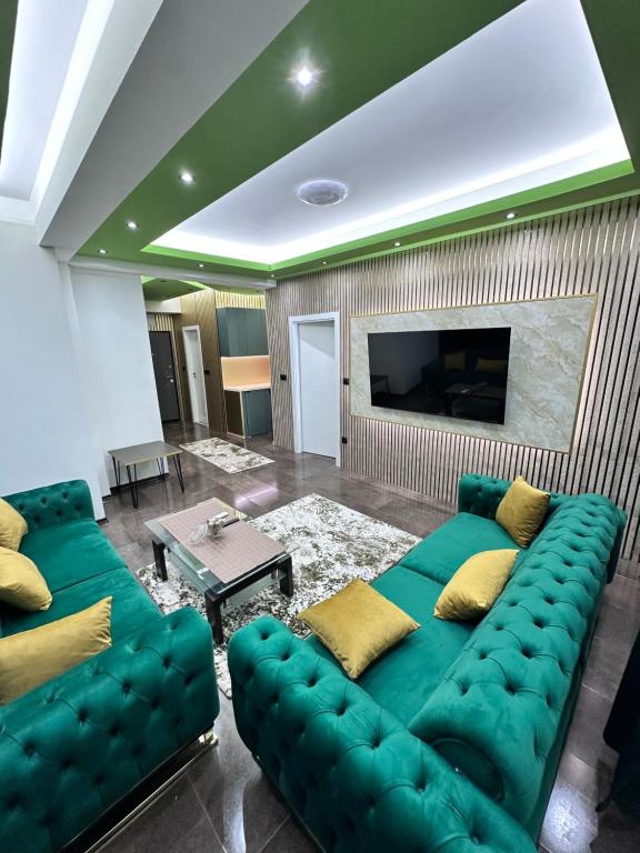 a living room with a green couch and a tv at Cataleya III in Sarajevo