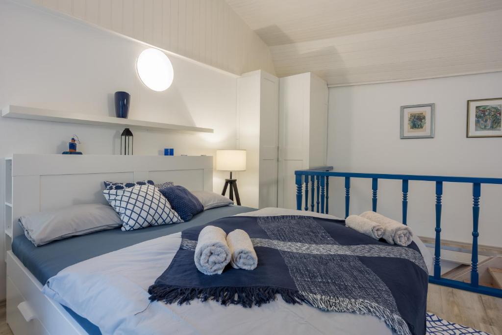 a bedroom with a blue bed with towels on it at Veli Lošinj Old Town Apartments in Veli Lošinj