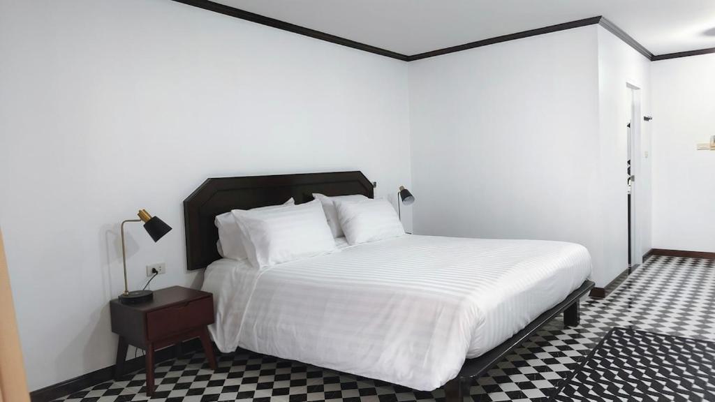 a bedroom with a white bed with a black and white floor at Le Noci Room 2203 in Ao Nang Beach