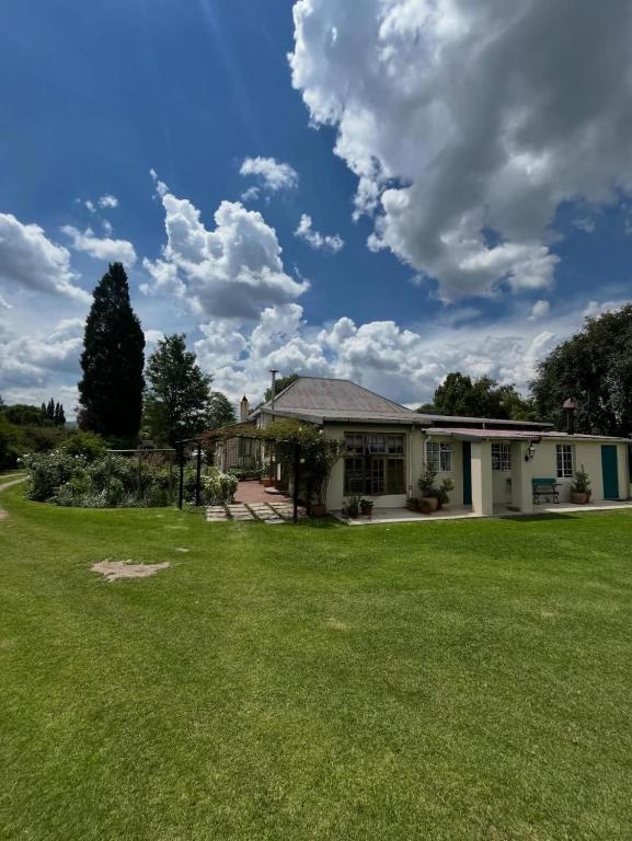 a house with a large lawn in front of it at Country Barns Guest house in Wakkerstroom