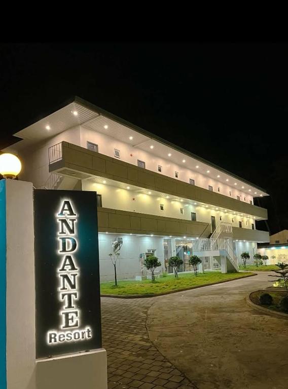 a building with a sign in front of it at night at Andante Beach Resort Batangas in San Luis