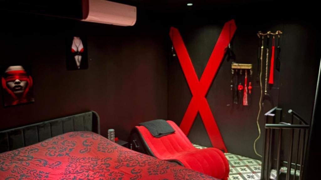 a bedroom with a bed with a x sign on the wall at L'instant Désir love room jacuzzi in Ferrières