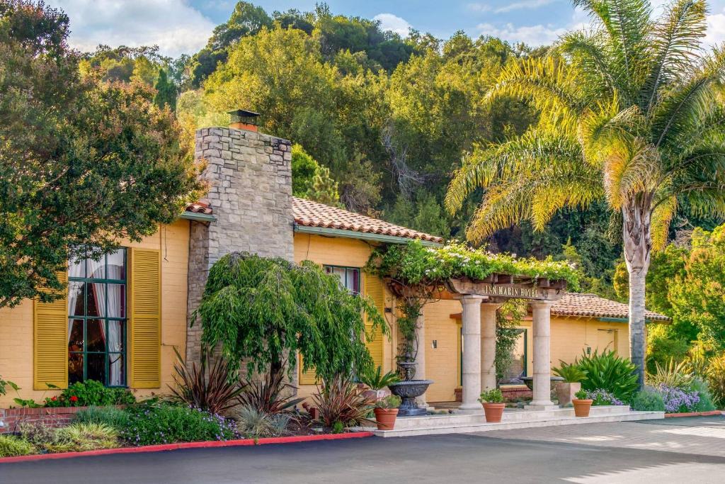 a yellow house with trees and palm trees at Inn Marin and Suites, an Ascend Collection Hotel in Novato