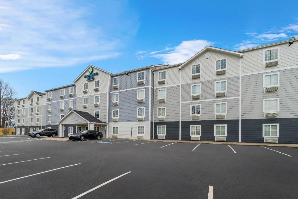 a large apartment building with a parking lot at WoodSpring Suites Memphis East I-40 in Memphis