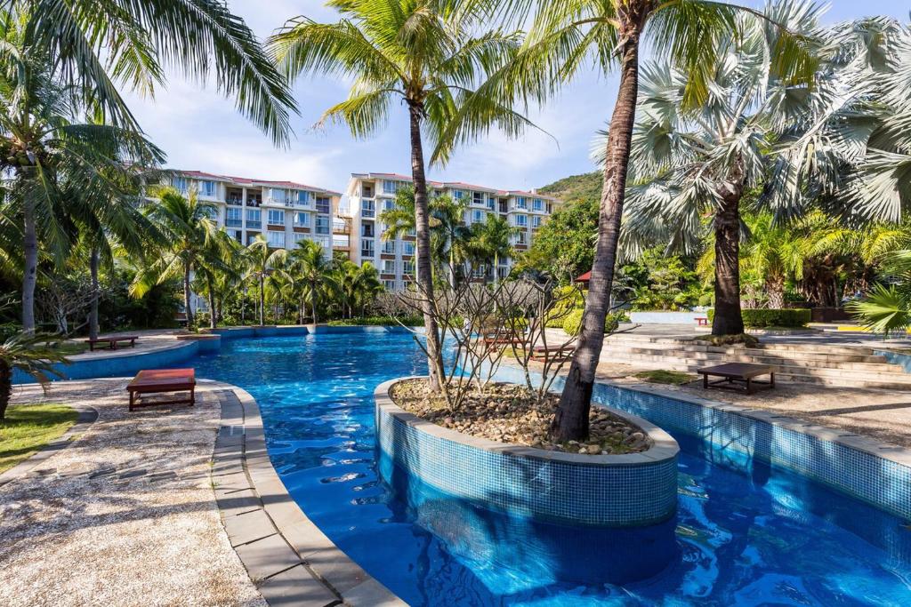 a swimming pool with palm trees in a resort at Yalong Sea Joy in Sanya
