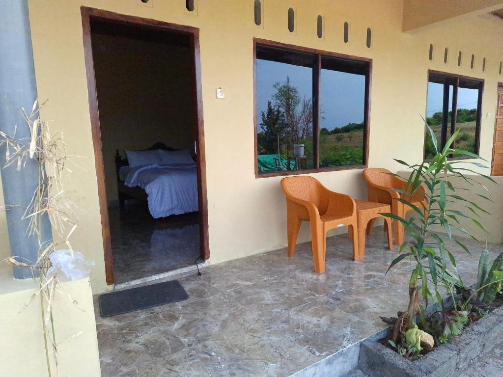 a room with a bed and a table and chairs at Amanda Ekas Homestay in Pulau Gilkaliantan
