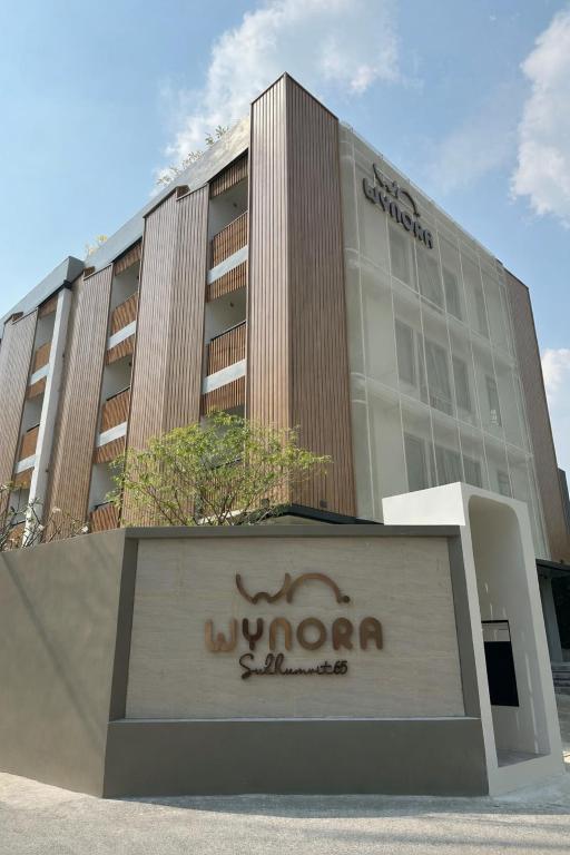 a building with a sign in front of it at Wynora Hotel in Klong Toi
