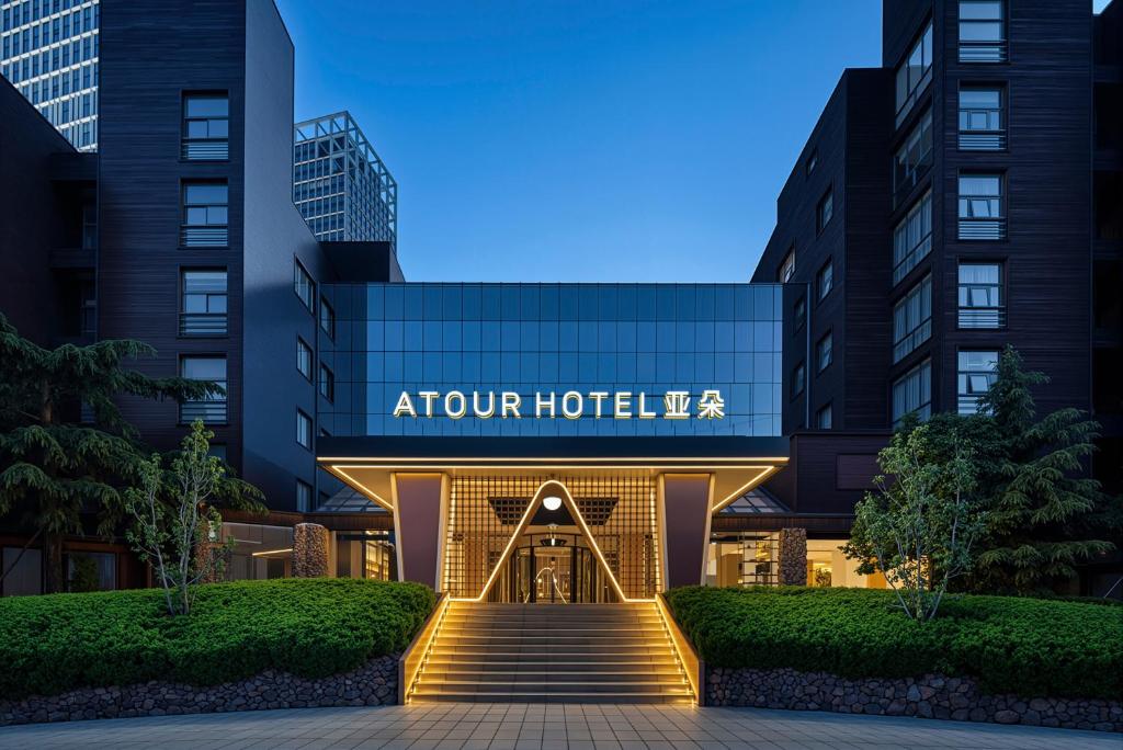 an exterior view of the atrium hotel at night at Atour Hotel Dalian Xinghai Square in Dalian
