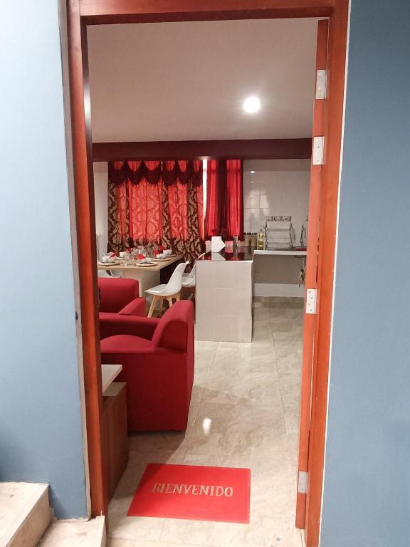 a living room with a red couch and a kitchen at Residencia Multifamiliar Sammy in Trujillo