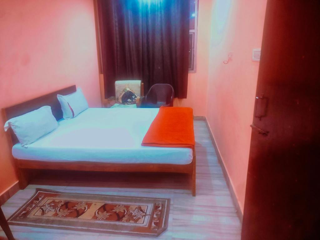 a bedroom with a bed with an orange blanket at Hotel shyama inn in Lucknow