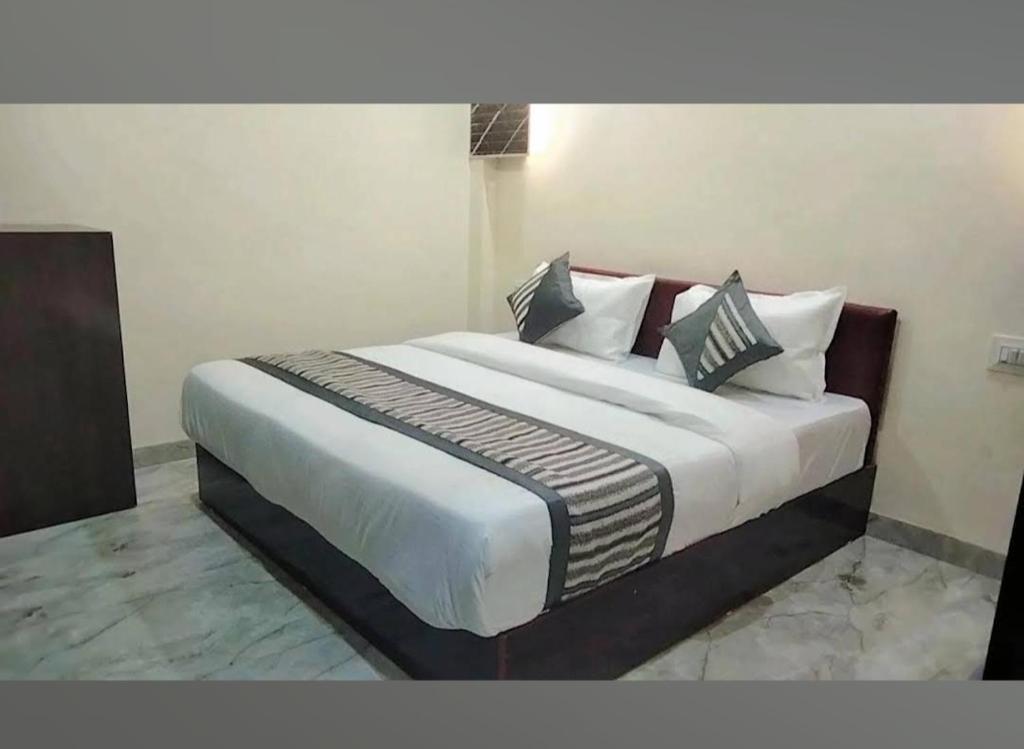 a bedroom with a large bed with white sheets and pillows at HoTEL DARBAR PALACE in Dewās