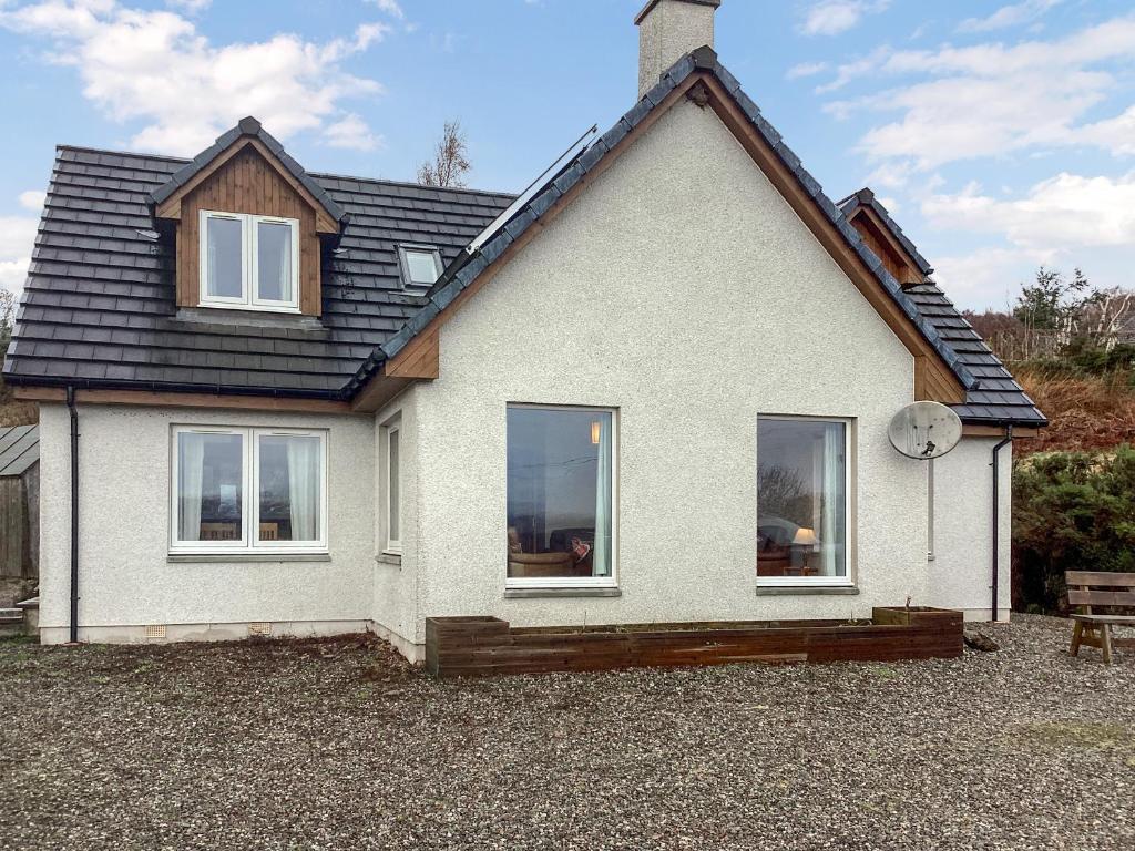 a white house with a black roof at Shedfield Cottage in Drumnadrochit