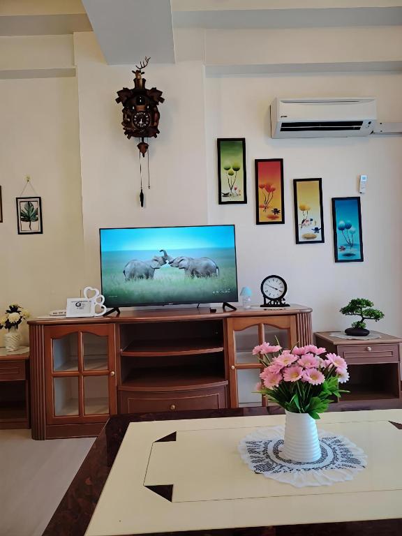 a living room with a television and a vase of flowers at Riverbank 904 in Kuching