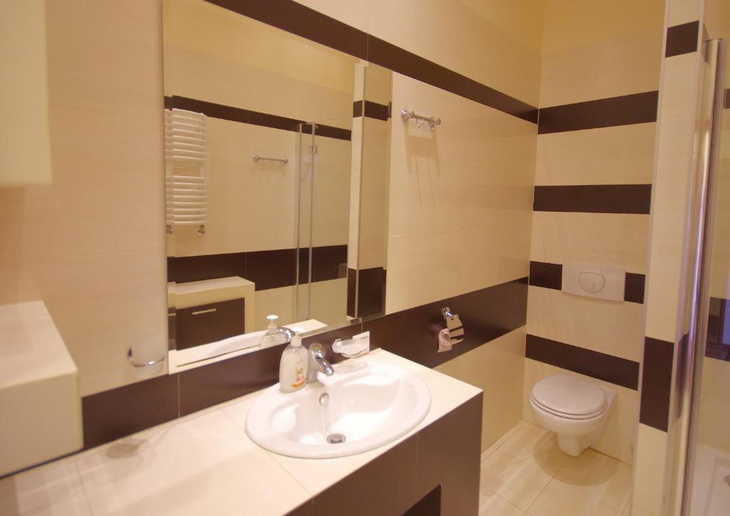 uma casa de banho com um lavatório e um WC em Apartamenty Pomerius em Kwidzyn
