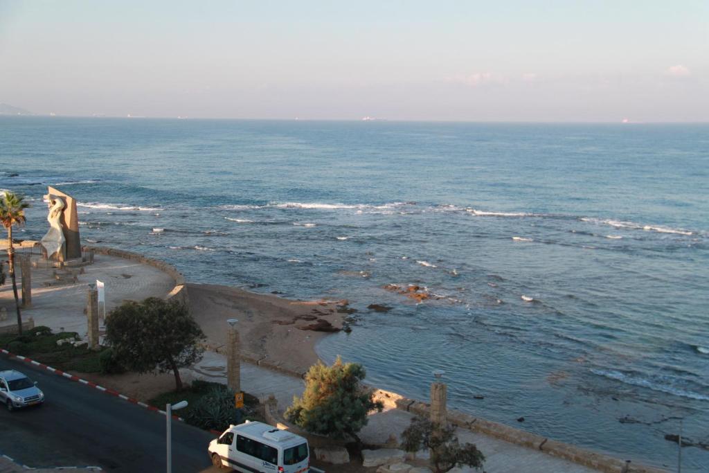 a view of the ocean with a car parked next to it at Voice of The Sea in Acre