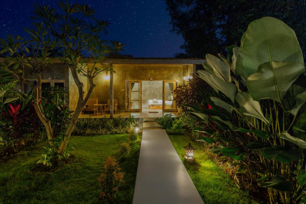 a garden path leading to a house at night at Menjangan Dive Lodge in Banyuwedang