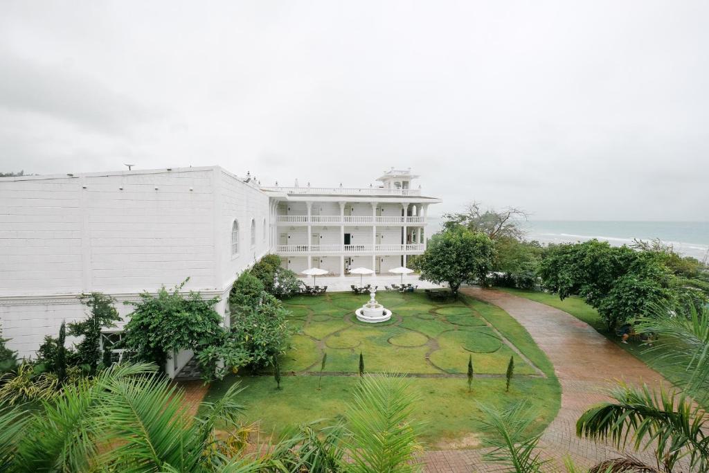 an external view of a white building with a garden at Bellissimo Minolos in Barili
