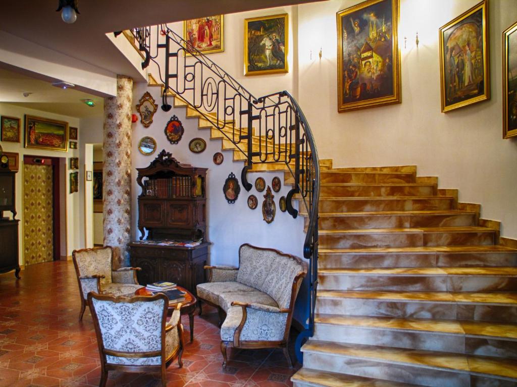 una sala de estar con una escalera con sillas y una mesa. en Hotel Puntijar, en Zagreb