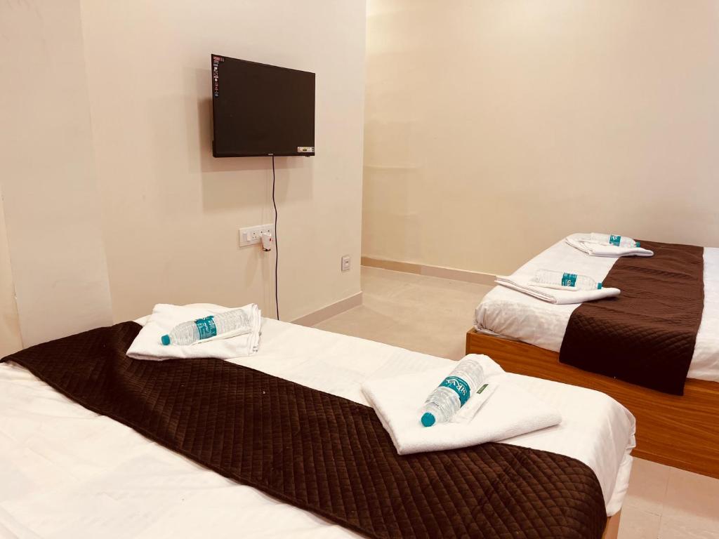 zwei Betten in einem Zimmer mit Handtüchern darauf in der Unterkunft Siya dormitory and rooms in Kolhapur