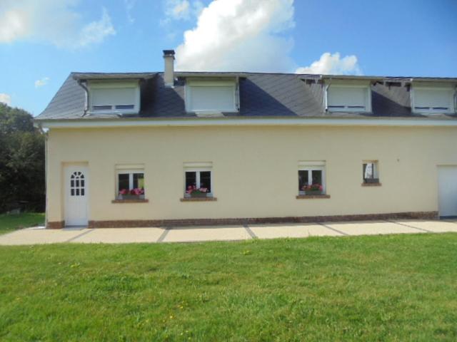 a large white house with windows and a green lawn at gîte des étangs in Nesle-Normandeuse