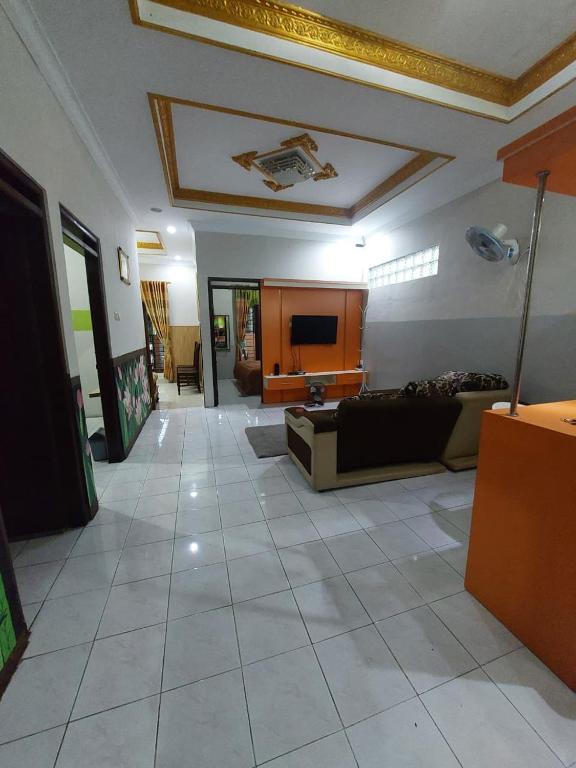 a living room with a couch and a television at Clara Guest House in Seturan