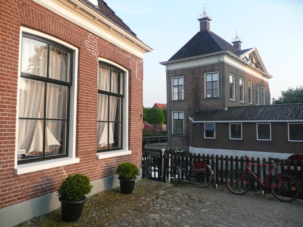 a brick building with two bikes parked next to a fence at Sonnehûs in Hindeloopen