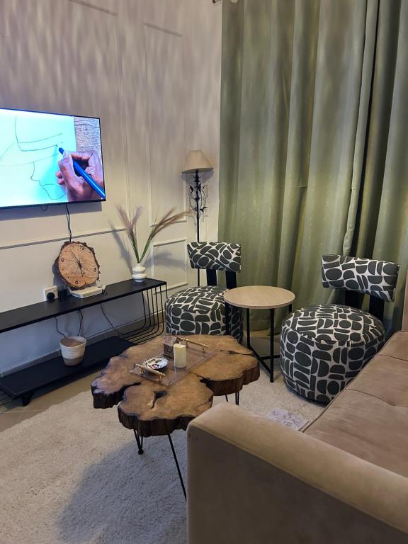 a living room with a couch and a flat screen tv at Serene Sidai in Nairobi
