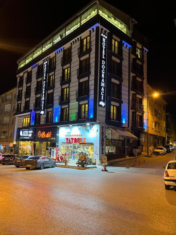 a building on a street with cars parked in front of it at Dogramaci Hotel City in Tosya