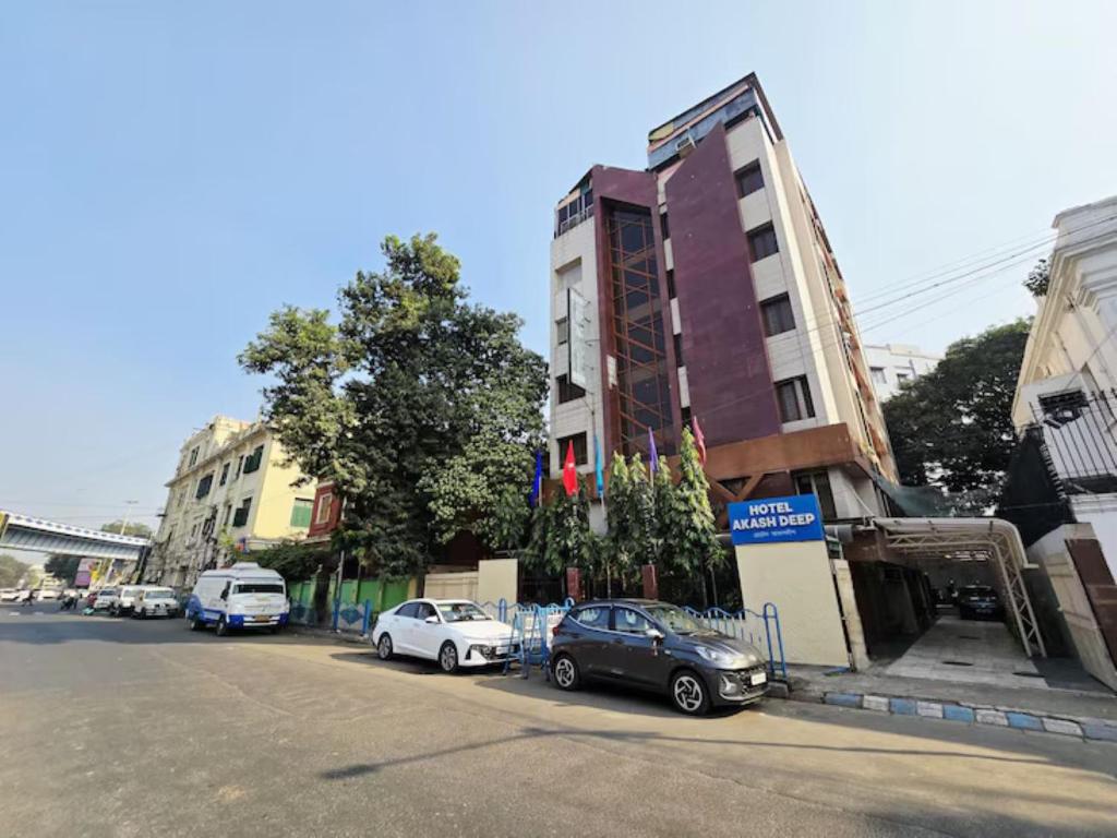a street with cars parked next to a building at Hotel Akashdeep in Kolkata